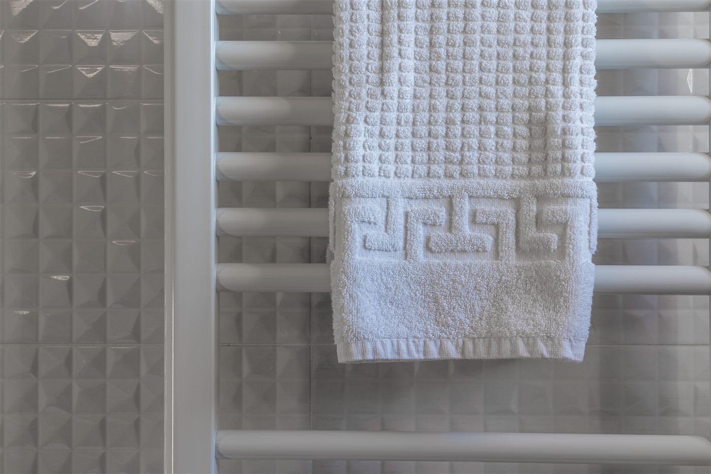 White towel rail radiator in a tiled bathroom